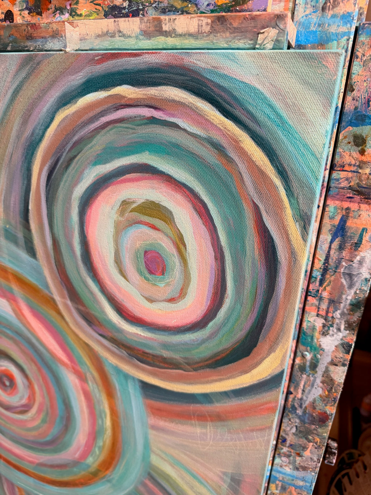 Close-up of Abundance showing layered rings of slate, blush, cream and teal with soft, dry-brushed texture.