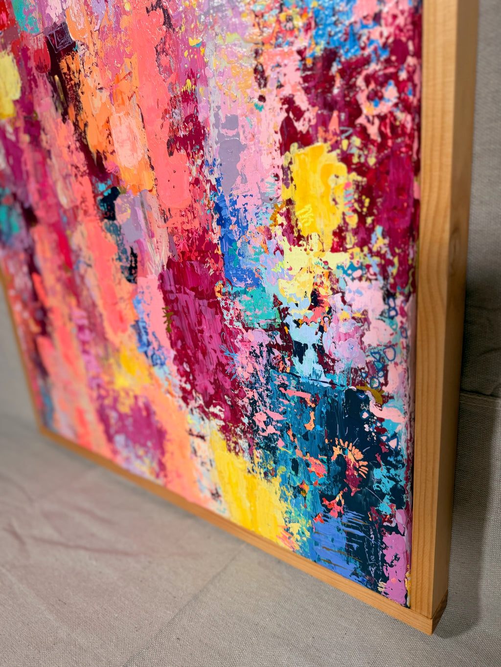 Angled close-up of Thought Trains, Like High Voltage Electricity Running Through My Veins showing thick, raised dabs of coral, magenta, yellow and navy paint beside the wood frame.