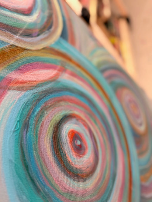 Close-up of Abundance showing nested rings of teal, blush, cream and copper paint spiraling out from a small red center.