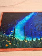 Angled close-up of The View From The Grass: a bright blue starry sky streaks above tall dark grass, slim poles and dots of glowing orange fireflies.