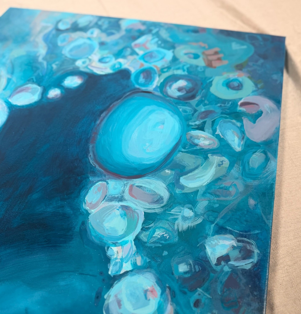 Angled close-up of Suspended In The Swell: a glowing aqua orb surrounded by layered, cell-like bubbles in teal, mint and soft pink over deep blue.