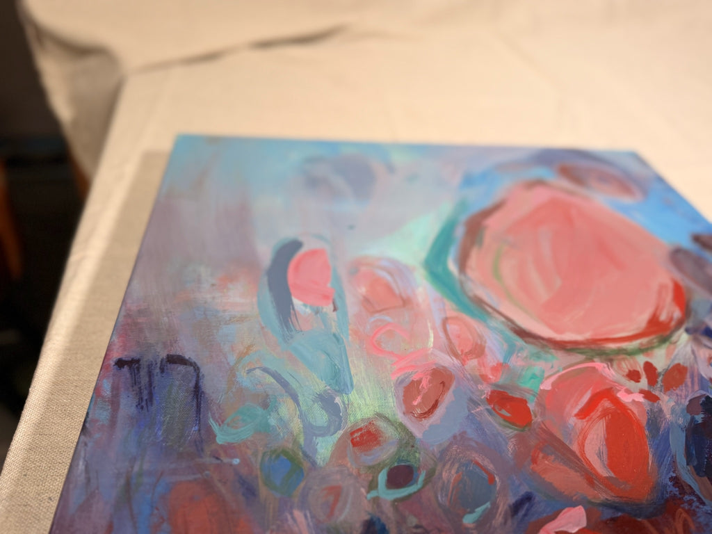 Angled view of Soul Nourished, I Bloom Anew lying flat, showing a large salmon-pink shape outlined in teal amid hazy blue and mauve circles.