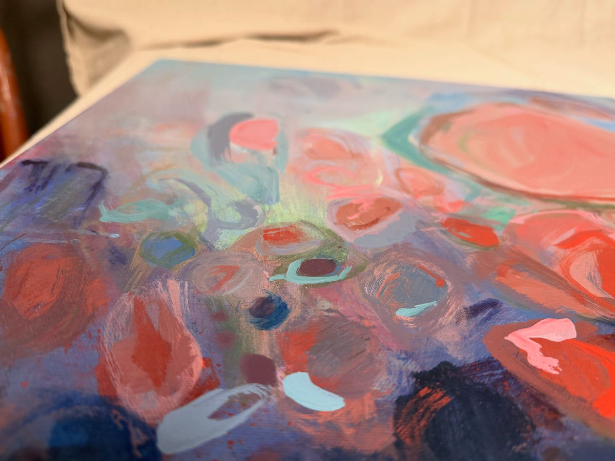 Close-up of Soul Nourished, I Bloom Anew: soft coral and pink rounded shapes float over periwinkle and navy, with flicks of mint and bright red.