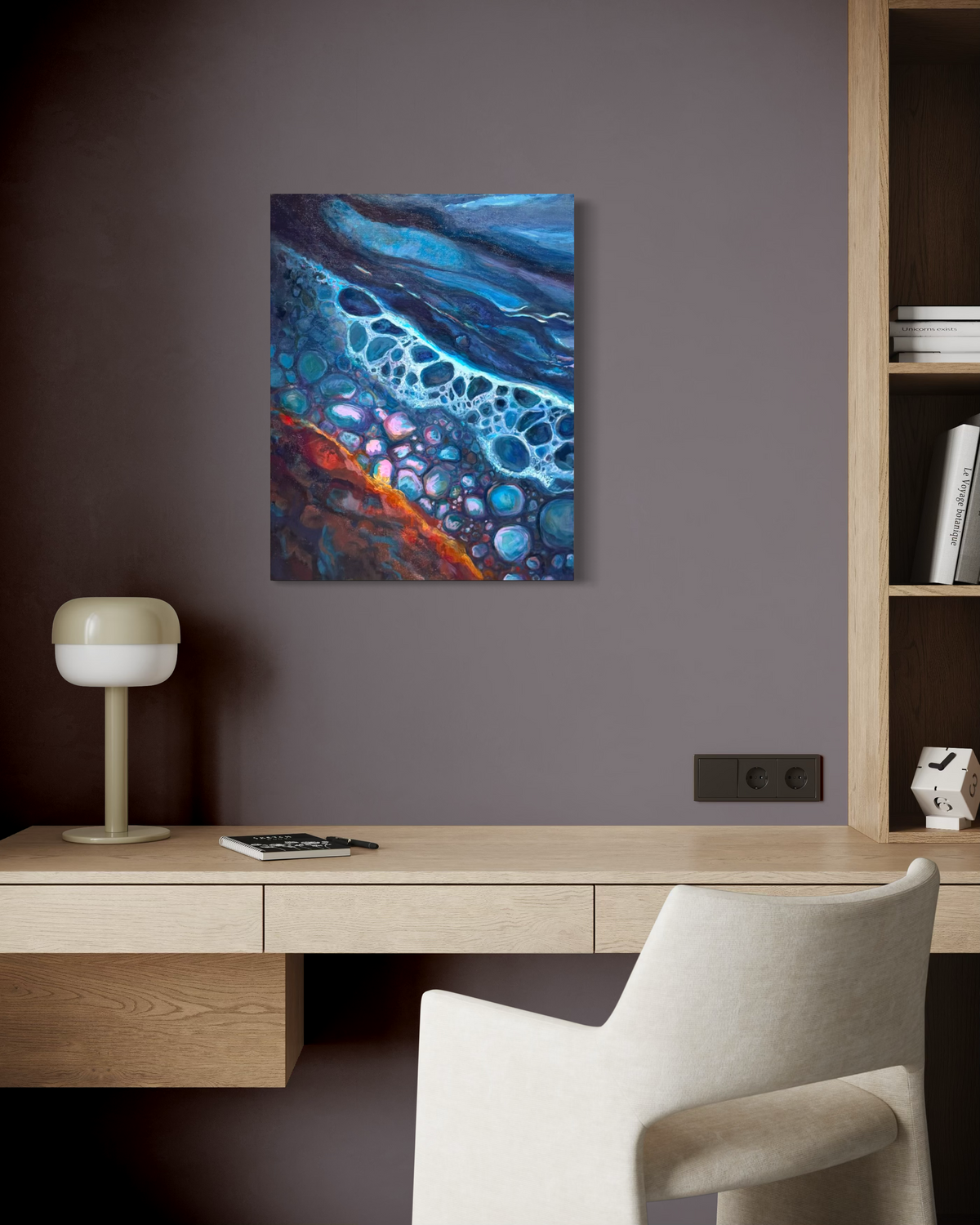 Polished By The Rough Torrent hanging above a light wood desk and white chair on a deep mauve wall in a modern office.