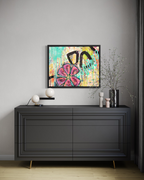 In Bloom hanging above a charcoal sideboard with small lamps and vases, its pink flower bright against turquoise drips and black curves.