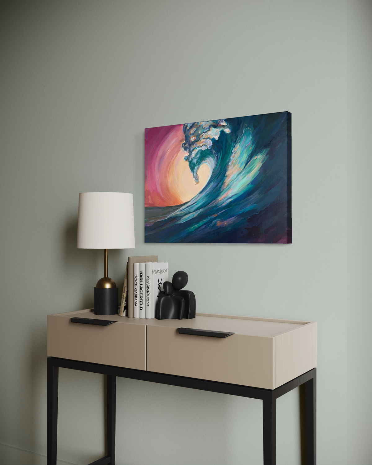 Held In The Current shown at an angle on a sage wall above a beige console with a lamp, its cresting teal wave glowing against a pink sunset.