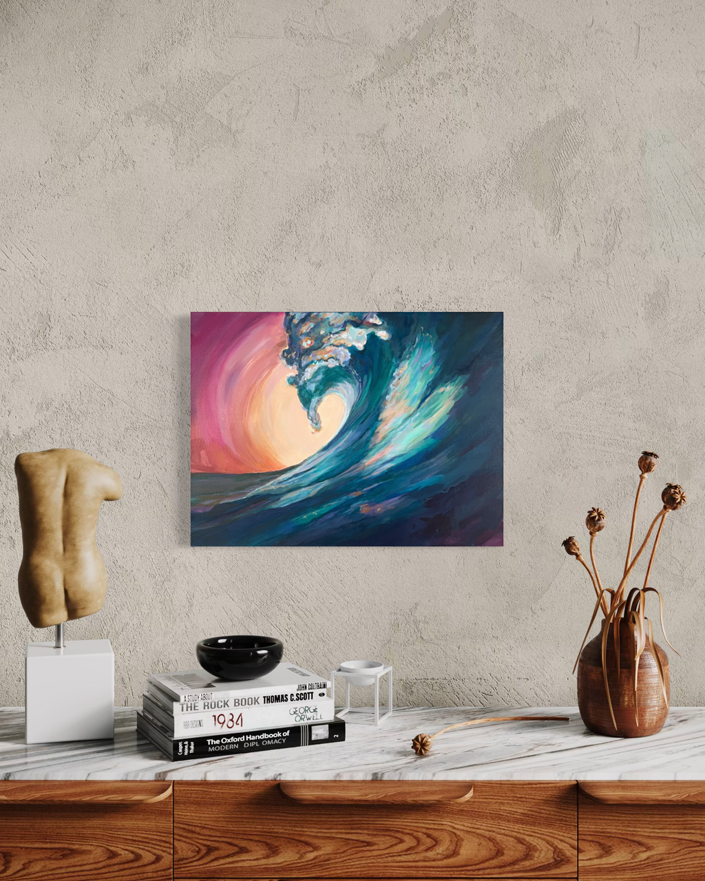 Held In The Current hanging on a textured plaster wall above a marble-topped wooden dresser with a sculpture, books and dried flowers.