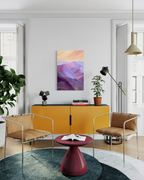The View From My Latest Summit, in mixed media on stretched canvas: layered purple and magenta mountains under a peach sunset sky, shown above a mustard cabinet.