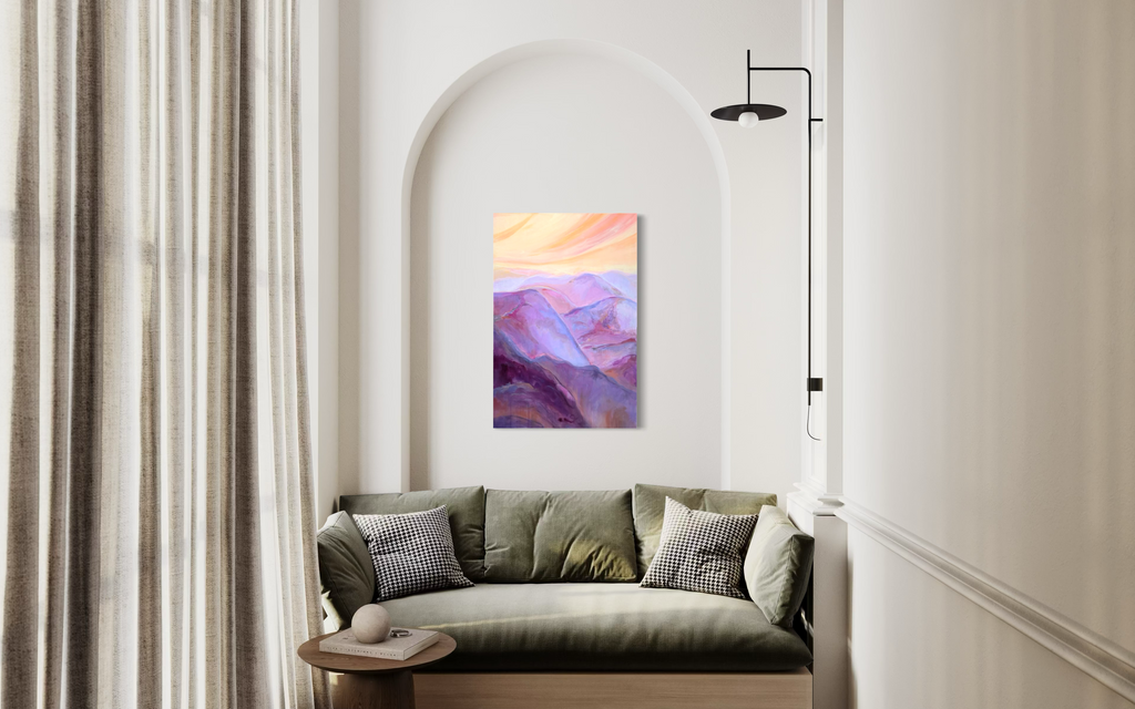 The View From My Latest Summit hanging in an arched alcove above an olive sofa, its purple mountain ranges glowing beneath a peach sky.