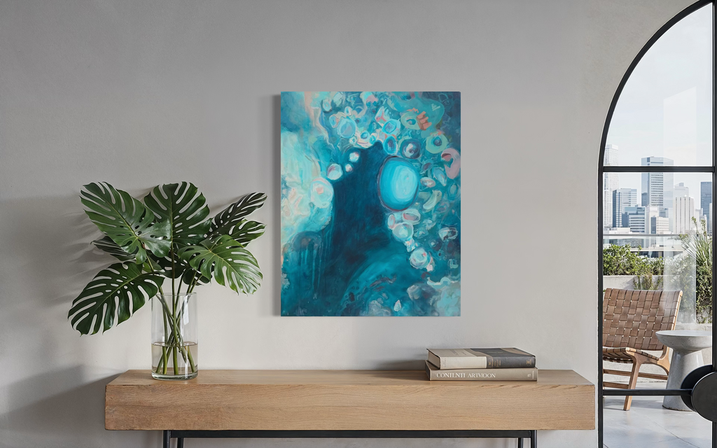 Suspended In The Swell shown above a wooden console with a monstera plant beside an arched window, its swirling teal water dotted with pale bubbles.