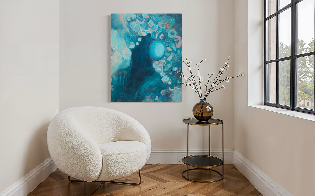 Suspended In The Swell hanging in a sunny corner above a white bouclé chair and small side table, its deep teal pool and aqua bubbles catching the light.