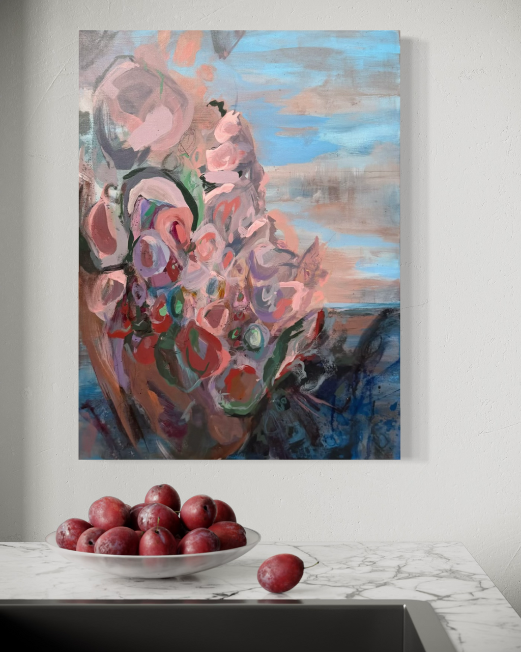 In Those Ashes, A Garden Grows, in mixed media on stretched canvas: pink and red blooms with green swirls under a blue and peach sky, shown above a marble counter with plums.